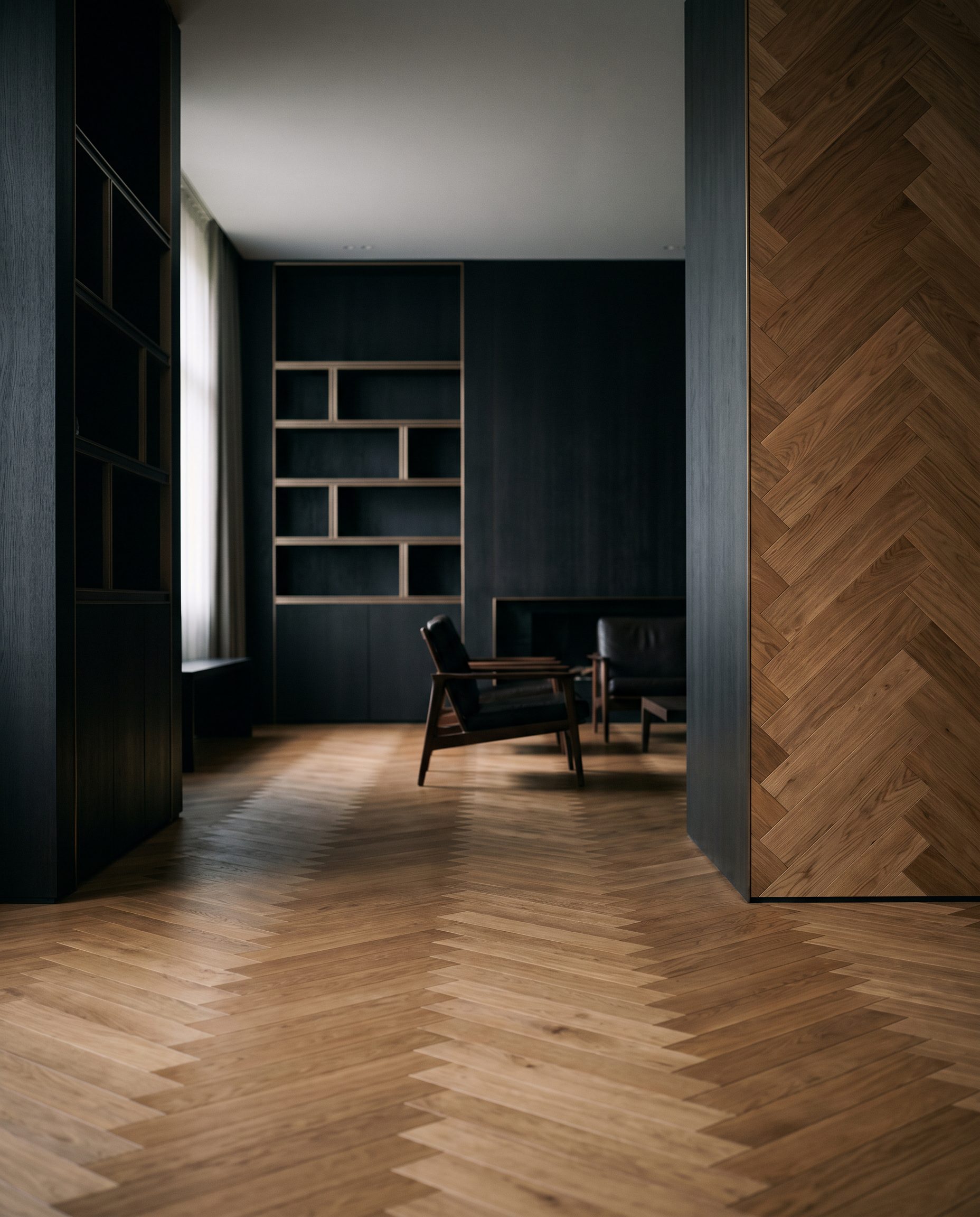 Wohnraum mit warmem Eichen-Fischgrät, das vom Boden auf die Rückwand hinter dem Sofa läuft — Wandkleid aus Parkett.
